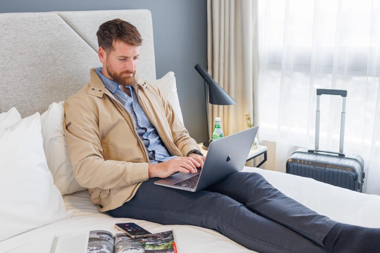 Meriton Suites Zetland Sidney Exterior foto A business traveler working on a laptop in a hotel room